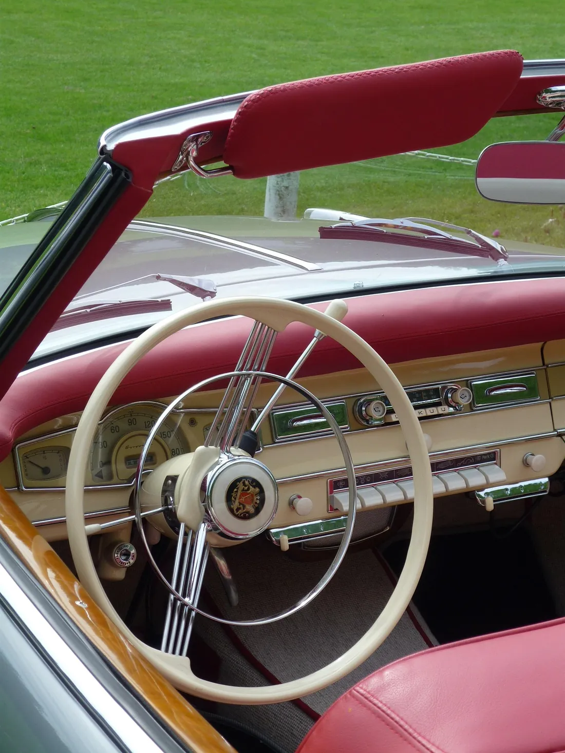 Intérieur d'une voiture de collection : volant, tableau de bord et pare-brise d'époque